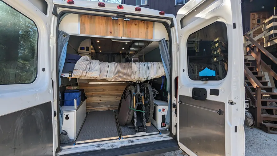 Elevated bed platform over a full-width gear garage — Big Bear Camper Vans build